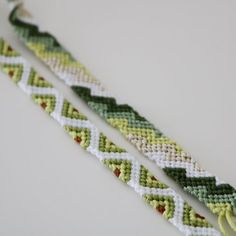 two green and white bracelets sitting next to each other on top of a table