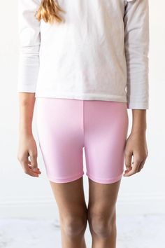 Our biker shorts are perfect for layering under dresses and skirts. When they dress themselves, sometimes they coordinate, sometimes they don't, but she's always covered when she practices cartwheels on the playground. Our biker shorts are high waisted for extra bum coverage. FIT - FABRIC - CARE: True to Size Polyester/Spandex Blend Wash cold/Tumble Dry Low BIKER SHORTS SIZE CHART Size Length (waist to bottom) Waist 6-12M 6.5" 13.4" 12-24M 7.1" 14.2" 2T 7.5" 15" 3T 8.3" 16.6" 4T 9" 17.8" 5/6 9.8 Dresses For School, Childrens Clothing Boutique, Active Play, Under Dress, Girls Rompers, Bubblegum Pink, Pink Shorts, Swimsuit Cover