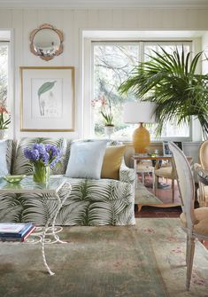 a living room filled with furniture and plants