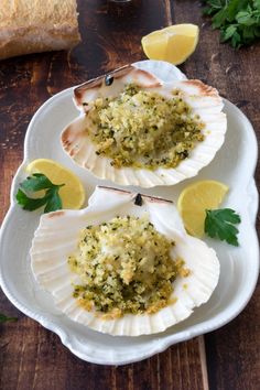 three clams with herbs and lemon on a plate