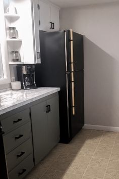 a black refrigerator freezer sitting inside of a kitchen