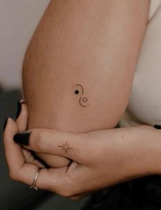 a woman's belly with a small tattoo on her left arm and the letter c in