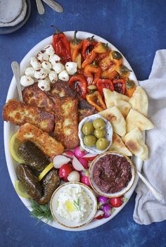 a white plate topped with different types of food next to utensils and sauces