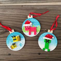 three handmade christmas ornaments on a wooden table