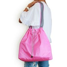 a woman is holding a pink bag in her hands