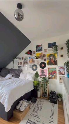 a bed sitting under a slanted ceiling next to a wall with pictures on it