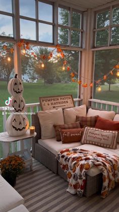 a porch decorated for halloween with pumpkins and jack - o'- lantern pillows