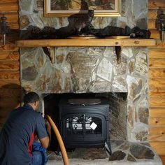 a man sitting in front of a fire place next to a painting on the wall