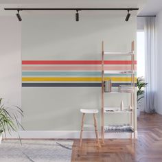 an orange and yellow striped wall mural in a living room with wooden flooring, white walls