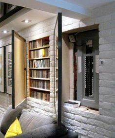 a living room filled with furniture and bookshelves next to a wall full of books