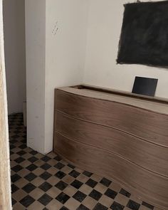 an empty room with a checkered floor and blackboard on the wall