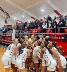 the girls basketball team celebrates with the trophy