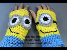 someone is holding their hand in front of the camera wearing a yellow and blue crocheted mitt