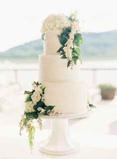 a wedding cake with white flowers and greenery