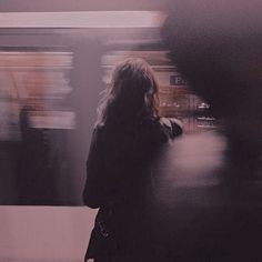 a blurry photo of a woman waiting for the train