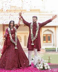 two people standing in front of a building and throwing confetti