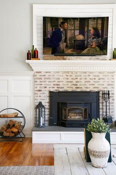 a living room with a fire place and tv above the fireplace in front of it