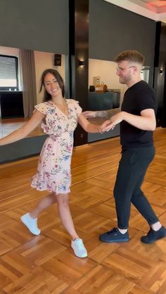 a man and woman are dancing on the dance floor in an empty room with wooden floors