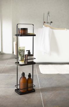 a bathroom with two bottles on the floor and a bathtub in the back ground