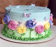 a multicolored cake decorated with flowers and butterflies