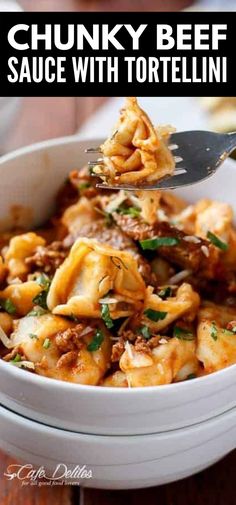 a white bowl filled with chunky beef sauce and tortellini