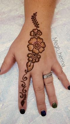 a woman's hand with henna tattoos on it