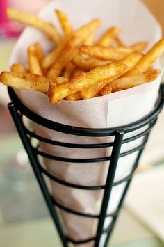 a basket filled with french fries sitting on top of a table