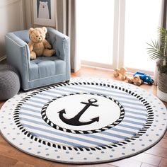 a child's room with a blue chair, teddy bear and an anchor rug