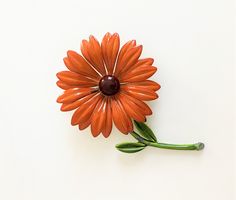 A very pretty metal flower brooch with orange enamel petals and a brown glass center. The circa 1960s  3 dimensional Black Eyed Susan pin.  Measures approx. 3 1/2 inches from flower to end of stem, approx. 1/2 inch deep. The pin is in good vintage condition on close examination you can see that one of the pedal tips is missing orange. Not noticeable from a distance.  See other Flower Pins for combined shipping! https://www.etsy.com/listing/1361753661/vintage-pink-and-yellow-pin-enamel-and? https Dogwood Blossoms, Metal Flower, Black Eyed Susan, Black Eyed, Enamel Flower, Pin Jewelry, Felt Dolls, Flower Pins, Metal Flowers