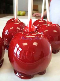 red apples are sitting on a table with toothpicks in the shape of an apple