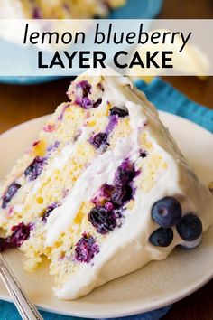 a slice of lemon blueberry cake with white frosting on a plate next to a fork