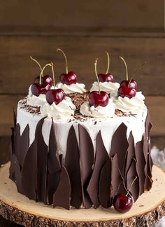 a cake with white frosting and chocolate icing, cherries on the top