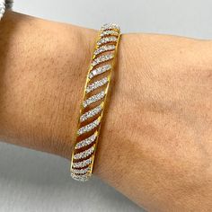 The Curves Bangles Set is inspired and created to reflect Indian tradition and design. With diamonds studded in a yellow gold, these bangles exude an ethereal glow. Total Diamond Weight: 7.70 ct No. of Diamonds: 400Diamond Color: G - HDiamond Clarity: VS Metal: 18K Yellow GoldMetal Wt: 34.46 gms Setting: Prong Set Inner Diameter: 2.4 Inches (6.10 cm) Fine Jewelry White Bangle With Single Cut Diamonds, White Bangle With Single Cut Diamonds, Dazzling Diamond Bangle Bracelet With Pave Setting, Exquisite Diamond Bangle With Single Cut Diamonds, Dazzling Diamond Cut Bangle Bracelet, Exquisite Diamond Cut Bangle Bracelet, Dazzling Diamond Bangle Bracelet, Exquisite Diamond Bangle Bracelet With Single Cut Diamonds, Luxury Gold Bangle With Brilliant Cut