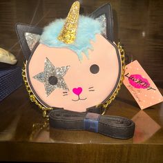 Add A Magical Touch To Your Style With This Betsey Johnson Cat Unicorn "Cat-I-Corn" Crossbody Bag. The Cute Bag Features A Pink, Black, Baby Blue, And Gold Color Combination With A Cat Unicorn Theme. The Faux Leather Material Ensures Durability, While The Crossbody Style Provides Convenience. The Betsey Johnson Kitsch Product Line Guarantees A Unique And Stylish Addition To Your Collection. Perfect For Women Who Love Fashion And Cute Accessories, This Bag Is Brand New Without Tags. Cat Unicorn, Betsey Johnson Wallet, Gold Color Combination, Bow Purse, Betsey Johnson Purses, Unique Backpacks, Black Gold Chain, Purple Quilts, Pink Crossbody Bag