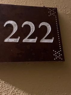 a black and white house number sign mounted to a wall with the numbers 22 22 on it