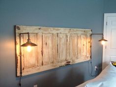 a bed with a headboard made out of wood and two lights on each side