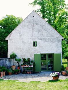 an old house with potted plants in front of it