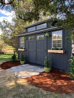 a small shed with plants in the windows