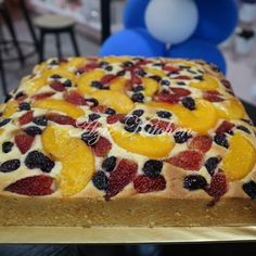 a cake with fruit on it sitting on top of a table