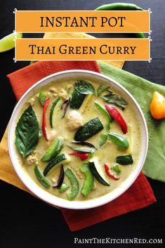 a white bowl filled with green curry and red bell peppers on top of a napkin