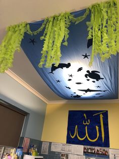 the ceiling in this classroom is decorated with blue and yellow paper streamers