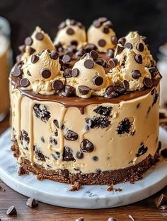 a cake with chocolate chip cookies and cream frosting sitting on top of a white plate