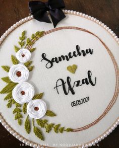 a white embroidered wedding ornament with flowers and leaves in the center on a wooden table