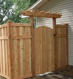 a wooden gate is next to a house