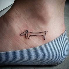 a small tattoo on the foot of a person with a dachshund design