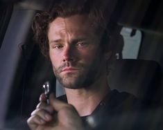 a man sitting in the back seat of a car holding a cell phone