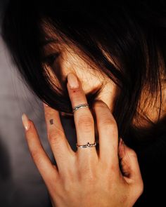 a woman holding her hand up to her face