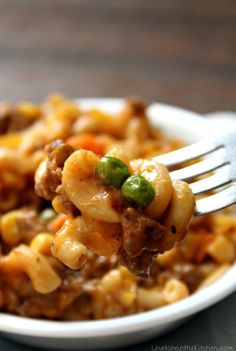 a fork full of pasta with meat and vegetables