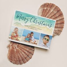 a christmas card with pictures of babies on the front and back, sitting on top of a seashell