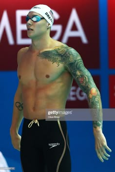 a man with tattoos on his arm and swimming trunks